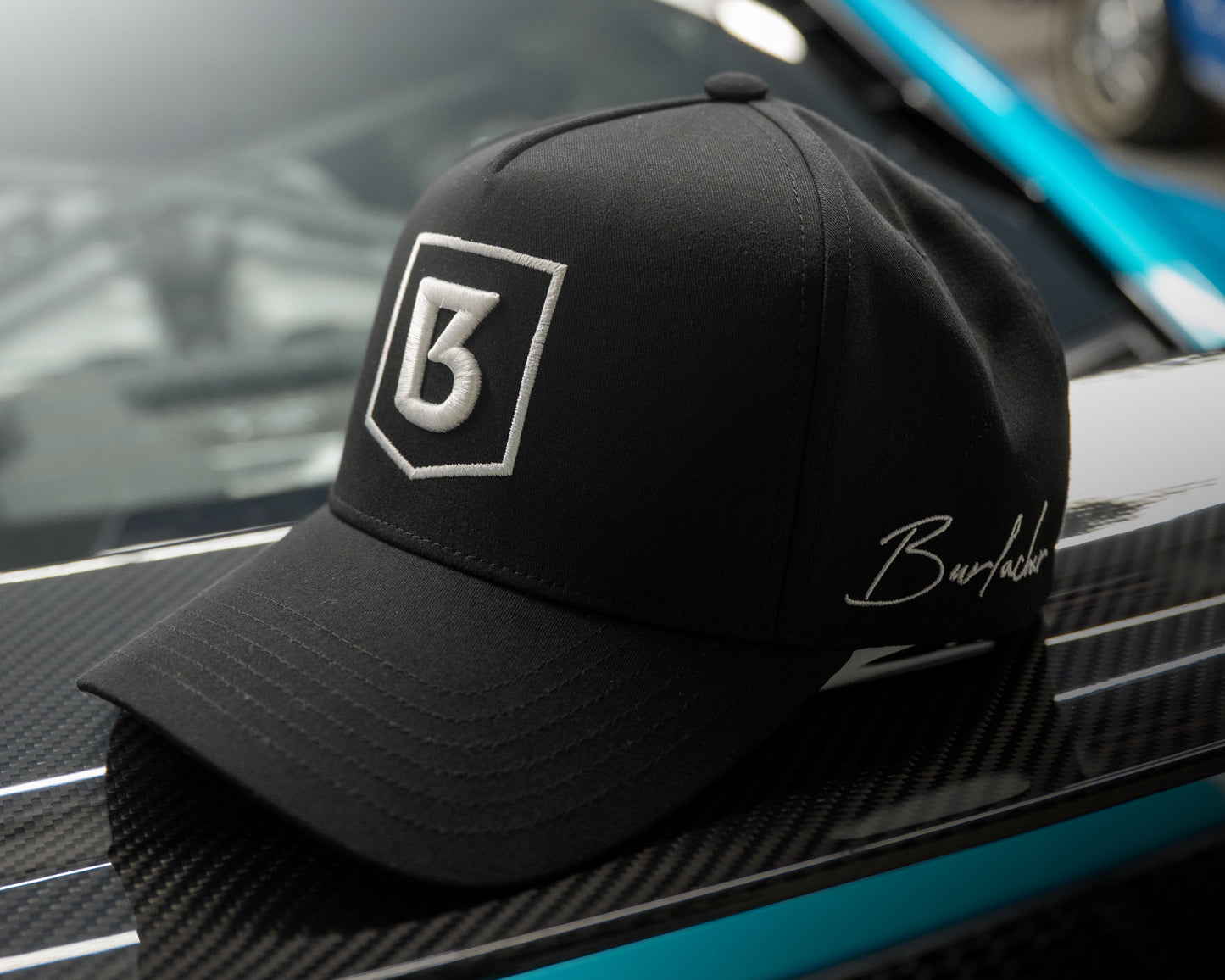 Black cap with a logo on a car's carbon fiber surface